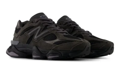 Pair of black New Balance 9060 sneakers with mesh panels, suede overlays, chunky soles, and gray accents on a white
