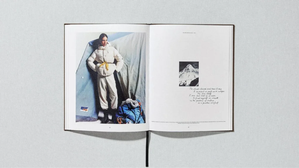 Open magazine spread showing a person in a white puffer outfit beside a blue backpack, with a mountain photo and handwritten