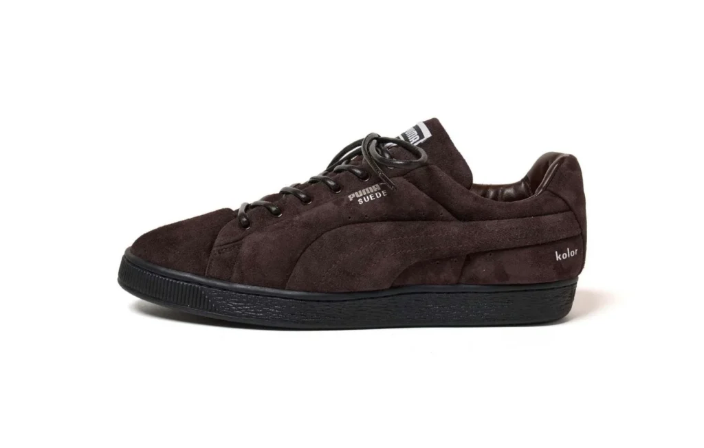 Dark brown Puma suede sneaker with black sole and laces, shown in side profile on a white background