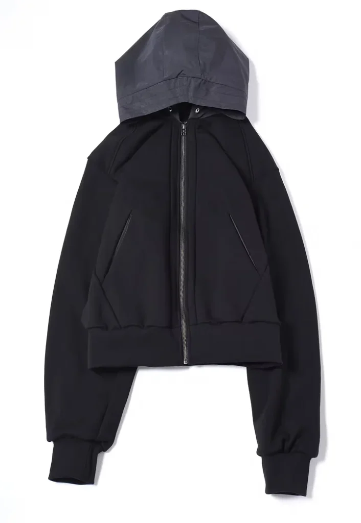 Black cropped zip-front jacket with oversized hood, long sleeves, ribbed cuffs, and angled pockets on white background