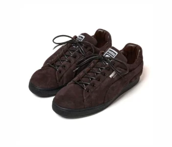 Pair of dark brown suede Puma sneakers with black laces and soles, displayed against a white background