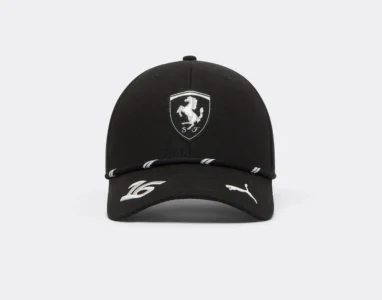 Black Ferrari cap with a silver prancing-horse shield, white Puma logo and white stripes on a plain light background
