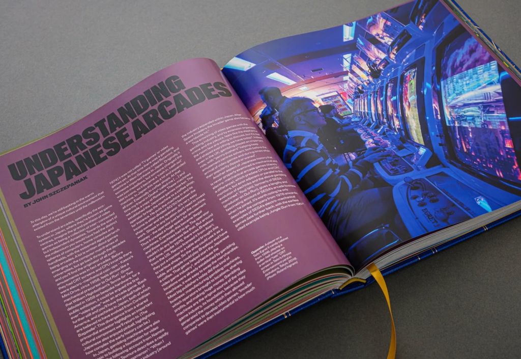 Open magazine spread with a pink text page and blue-lit photograph of people playing arcade games beside machines