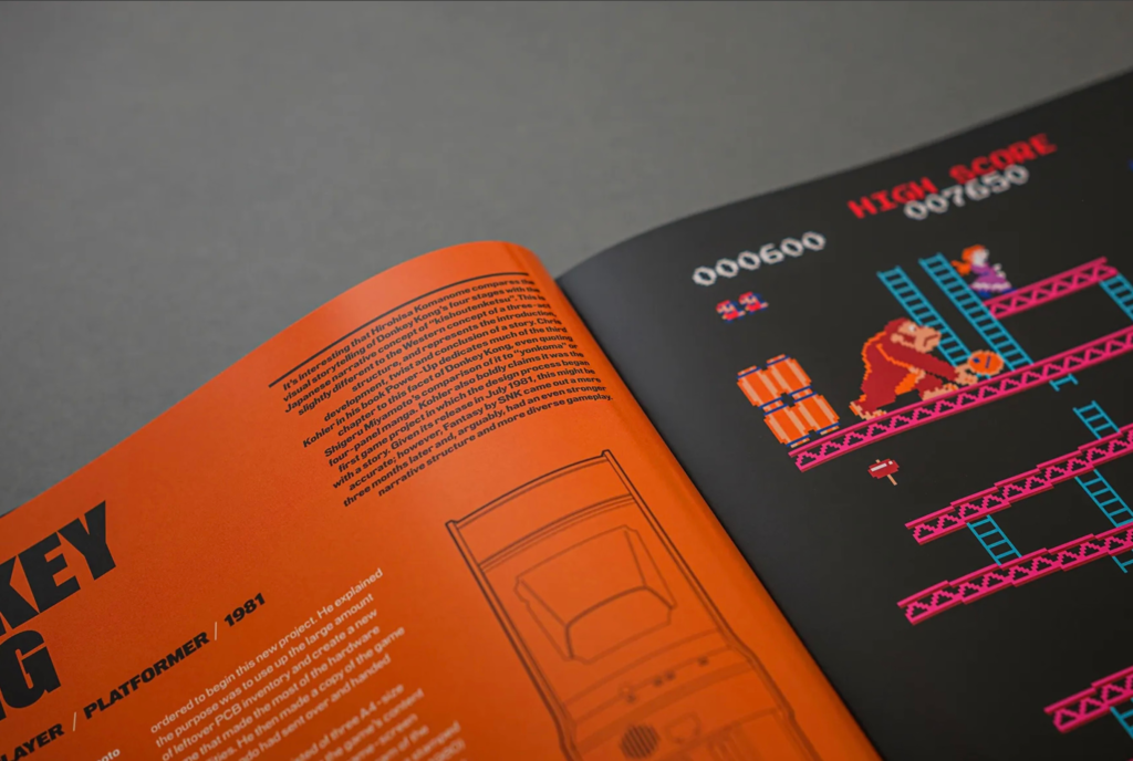 Open book showing orange text pages beside a black Donkey Kong game screen with colorful pixel graphics