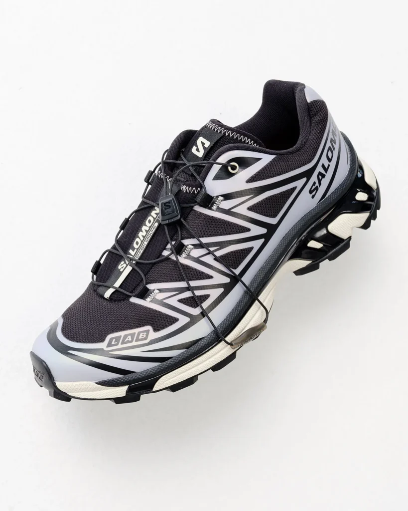 Black-and-white Salomon trail shoe with bold graphics, quick-lace system and rugged outsole on a white background