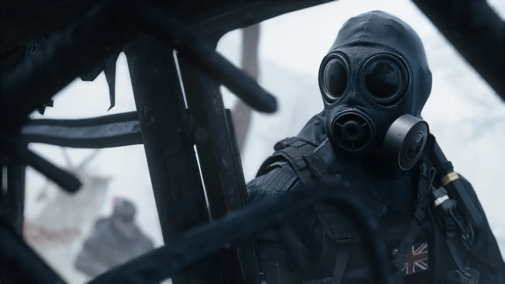 Masked soldier in black tactical gear and Union Jack patch, viewed through dark aircraft framework against a bright sky