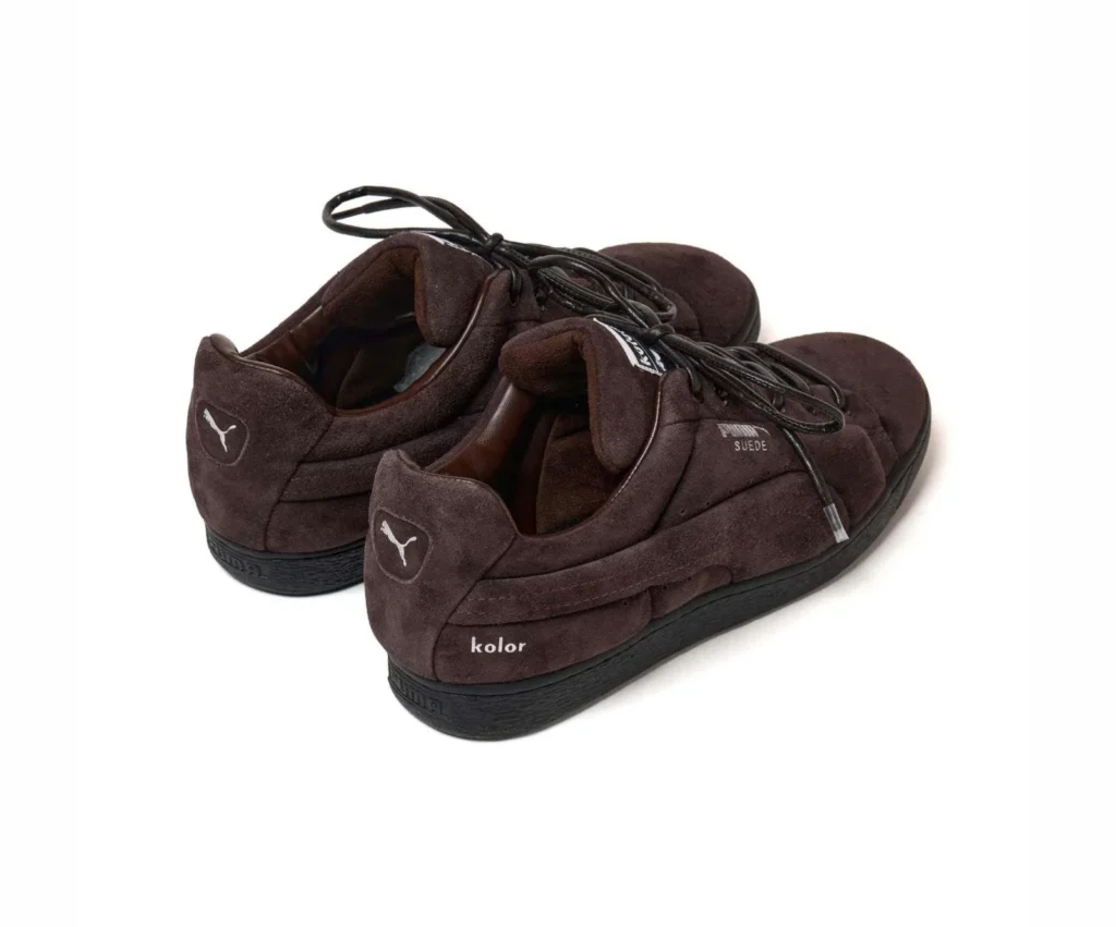 Pair of brown Puma sneakers with black laces, suede uppers, white logos, and black soles
