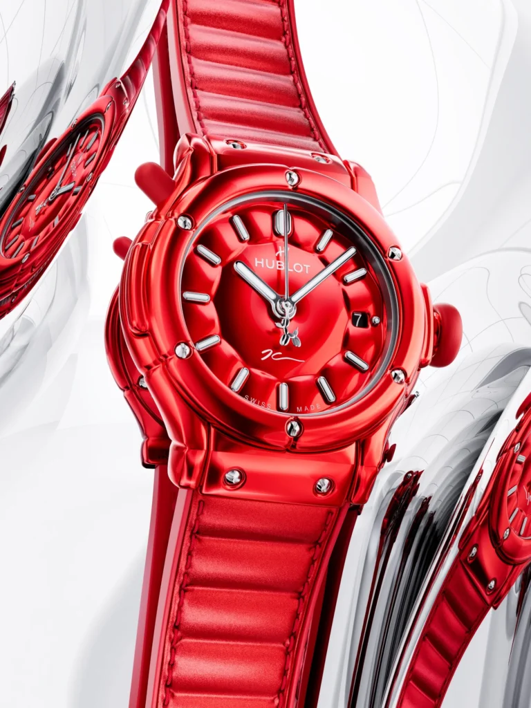 Red Hublot wristwatch with a red strap, black-and-silver hour markers, and a date window on a white background
