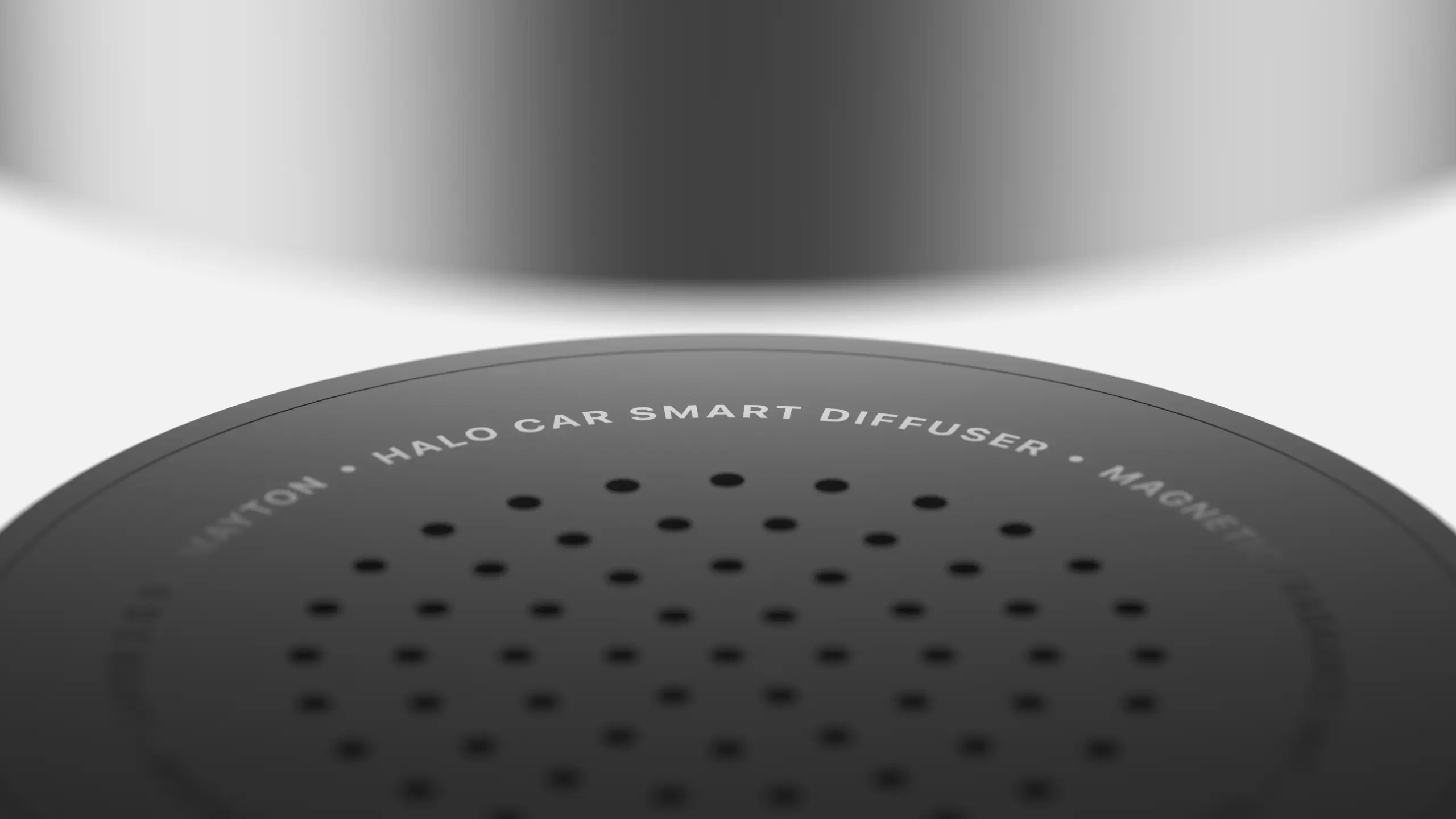 Close-up of a dark gray circular car diffuser with perforations and white “HALO CAR SMART DIFFUSER” lettering