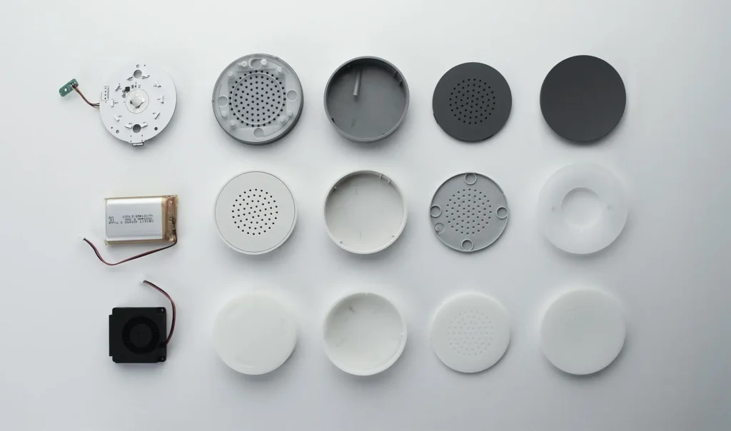 Disassembled car air freshener diffuser components arranged in rows on a white surface