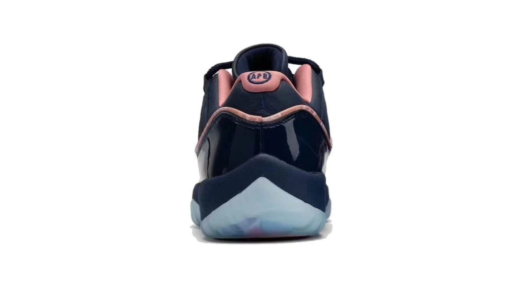 Front view of a black sneaker with pink trim, glossy panels, and a translucent pale blue sole on white background