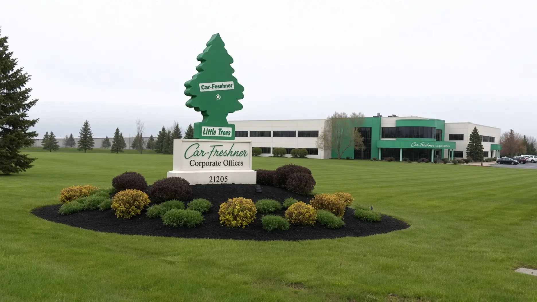 Car-Freshner corporate office behind a landscaped lawn and a large green tree-shaped sign reading “Little Trees”