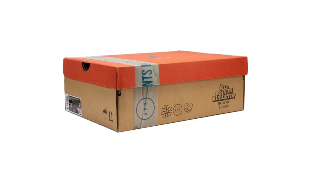 Orange-lidded brown cardboard shoebox with blue-and-white tape and printed handling symbols on a white background