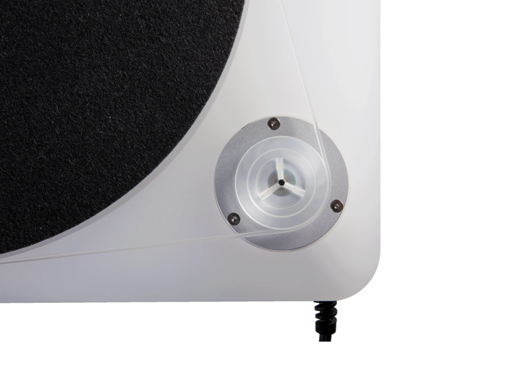 Close-up of a white turntable showing its exposed clear belt drive, silver motor housing, and black platter mat