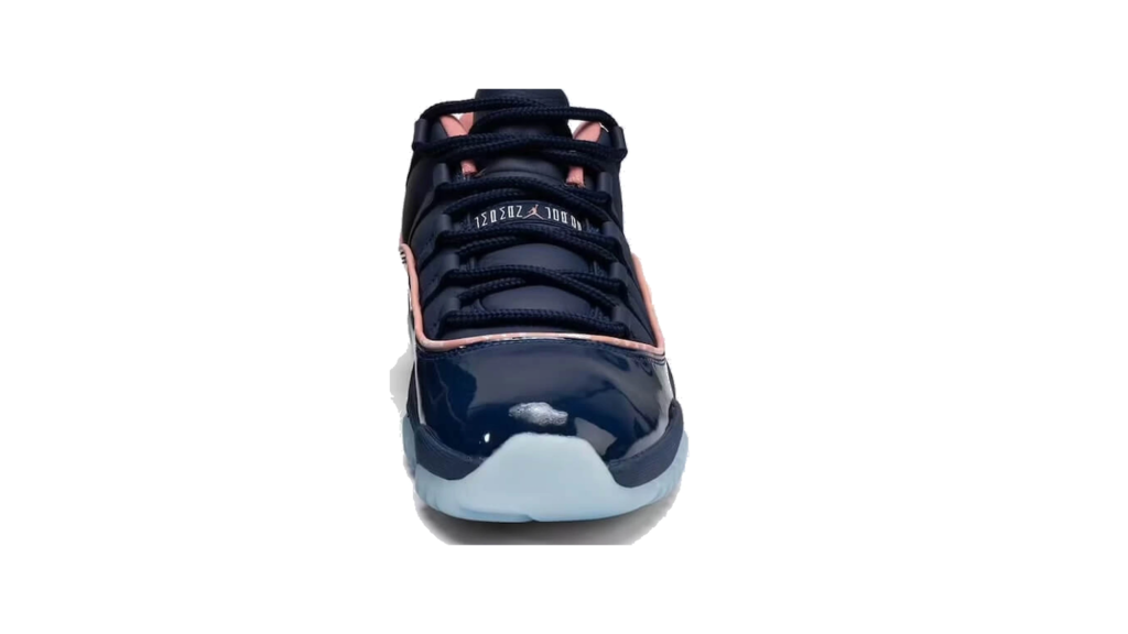 Front view of a black patent sneaker with pink trim, black laces, white sole, and tongue branding on a white background
