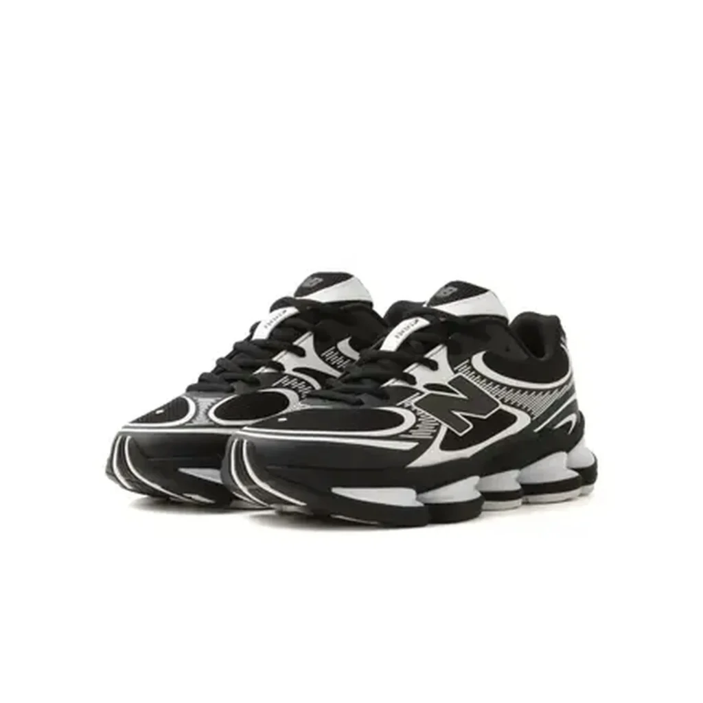 Pair of black-and-white New Balance shoe with oversized logos and segmented soles on a white background