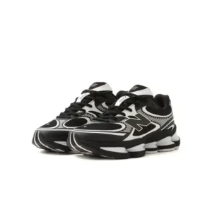 Pair of black-and-white New Balance shoe with oversized logos and segmented soles on a white background