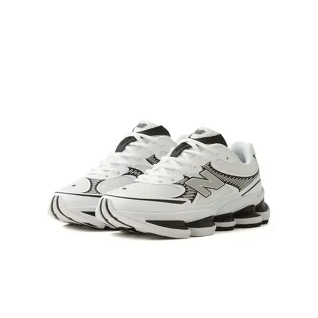 Pair of white New Balance shoe with black and gray accents on a white background