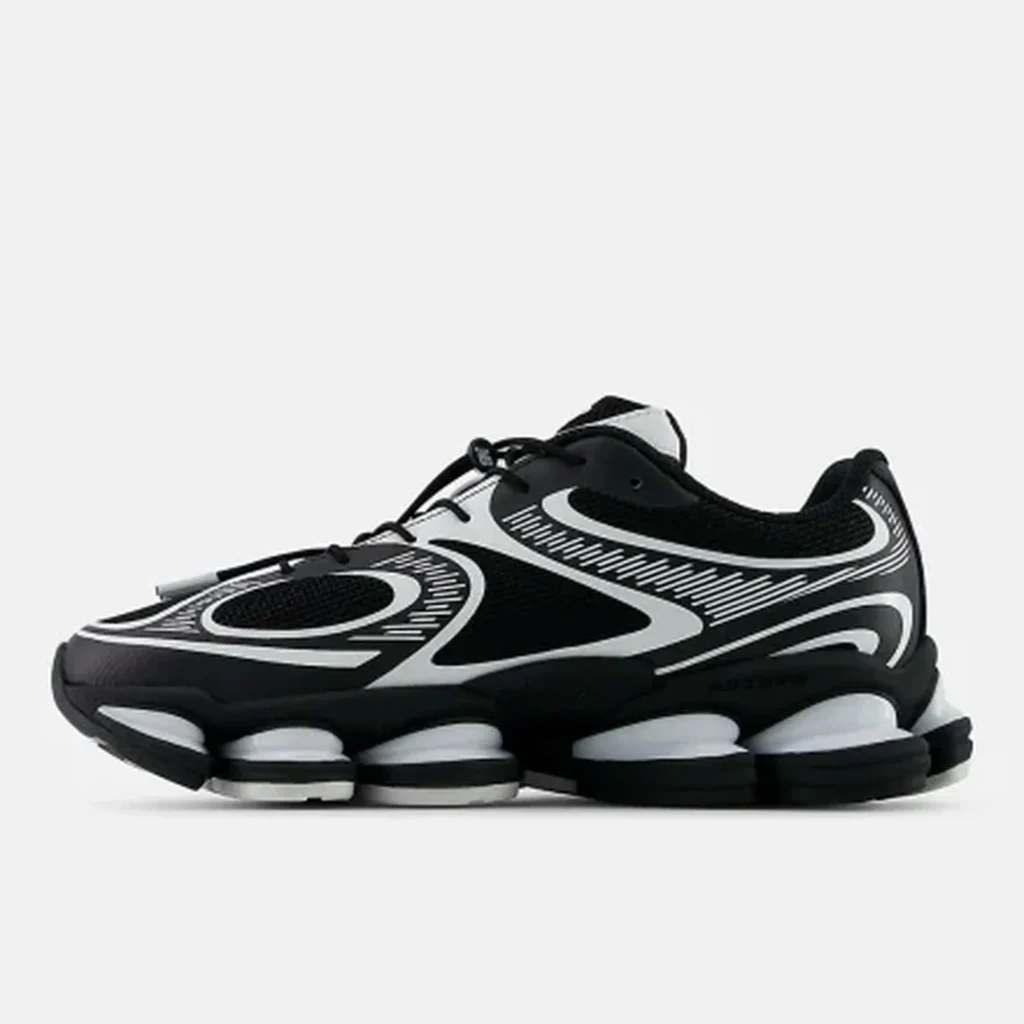 Black-and-white Nike sneakers with bold curved graphics and segmented white cushioning, shown in side profile on a light