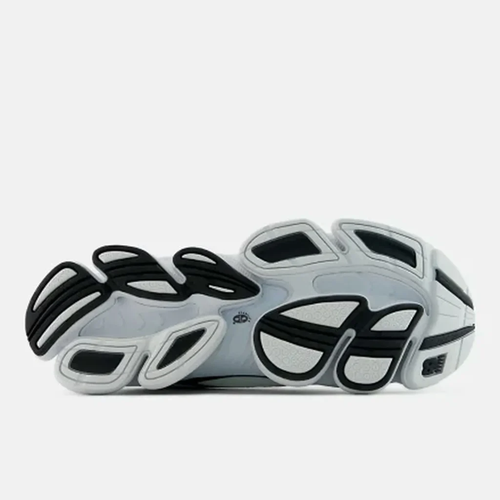 White and black New Balance shoe with layered looped overlays and cutout panels, shown in side profile on a white