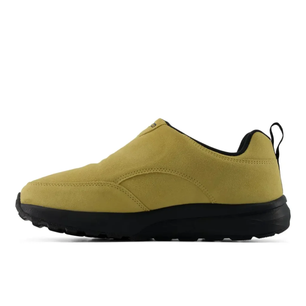 Mustard yellow slip-on sneaker with black sole and heel loop, shown in side profile against a white background