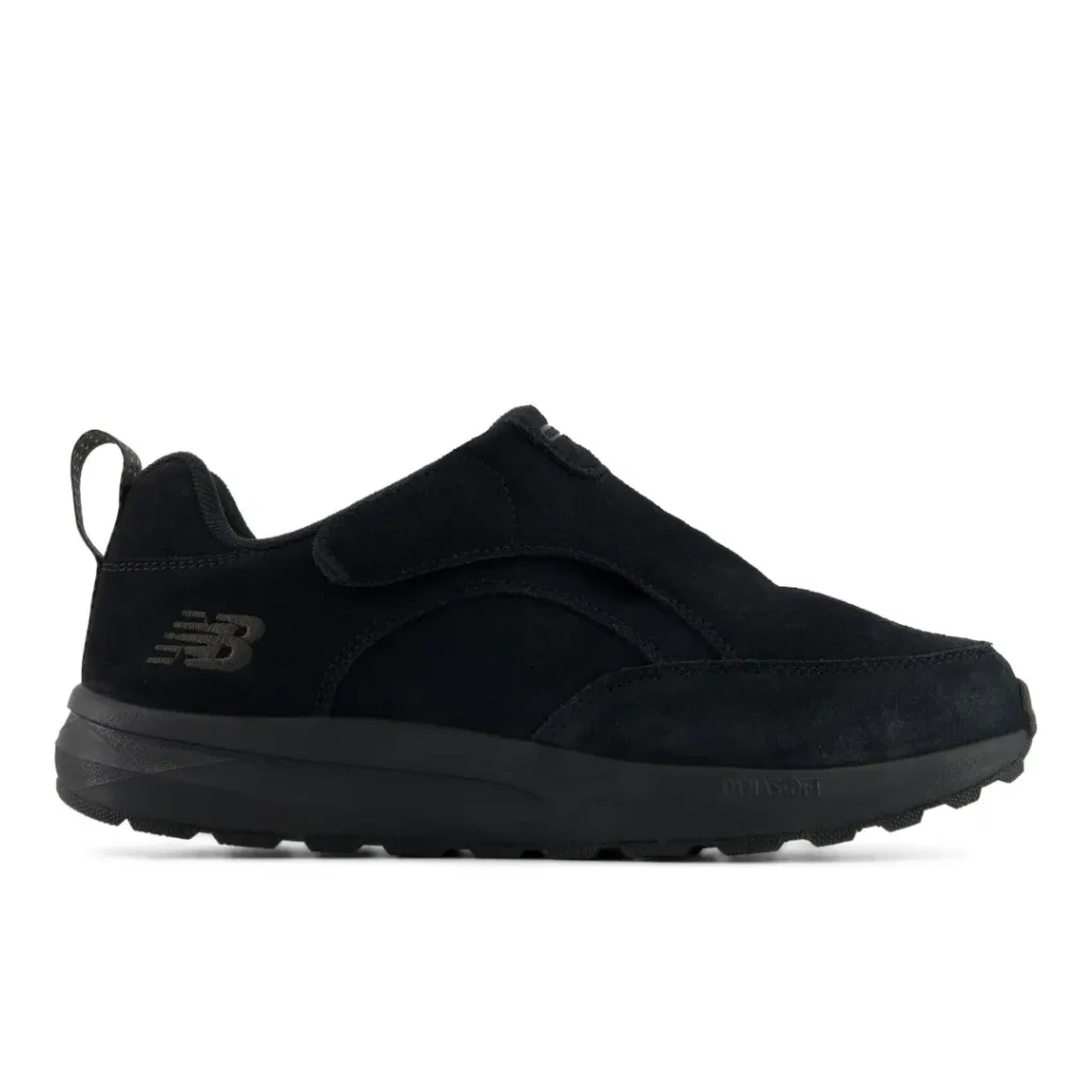 Black New Balance sneaker with a wide hook-and-loop strap, pull tab, textured panels and thick lugged sole on white