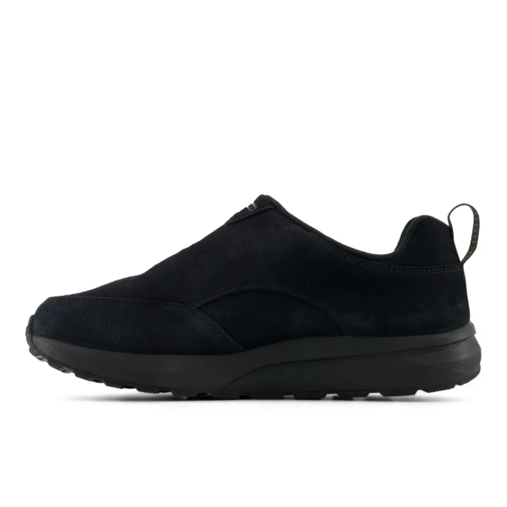 Black slip-on sneaker with a streamlined upper, thick cushioned sole, and rear pull tab on a white background