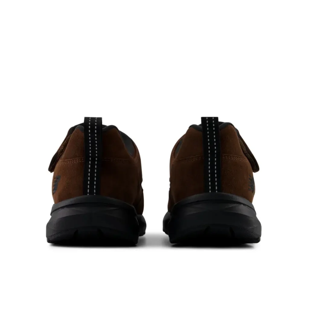 Rear view of brown suede sneakers with black soles and reflective heel pull tabs against a white background