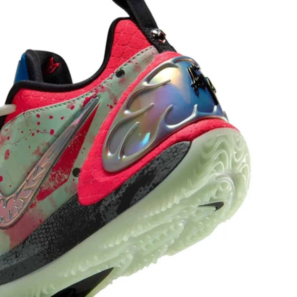 Close-up of a red and mint Nike basketball shoe with blood-splatter graphics, iridescent panel, and translucent