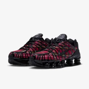 Pair of black Nike sneakers with red and multicolor plaid uppers and segmented Shox cushion on a white background