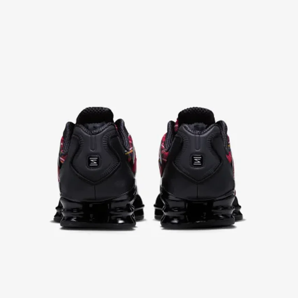Pair of black sneakers shown from the rear, with colorful plaid side panels and segmented cushioning under the soles on
