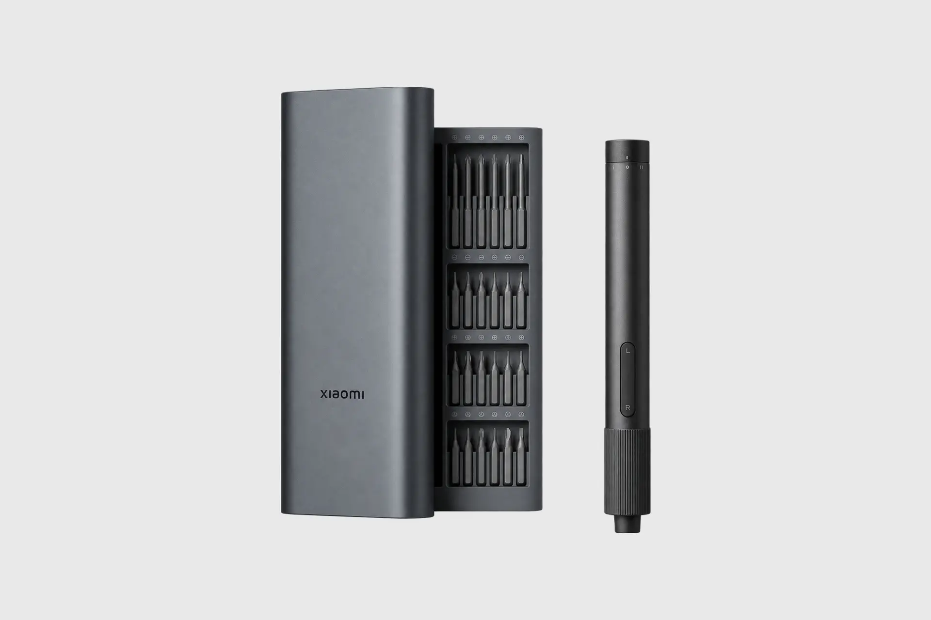 Xiaomi cordless precision screwdriver, bit case, and gray metal storage sleeve arranged against a light gray background